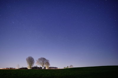 Scenic view of field against clear sky at night