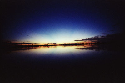 Scenic view of lake against clear sky during sunset