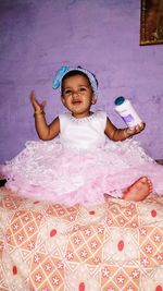 Portrait of cute baby girl sitting at home