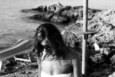 Woman wearing bikini while standing on rocky shore