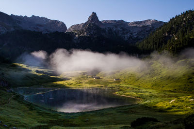 Scenic view of berchtesgaden alps against clear sky in foggy weather