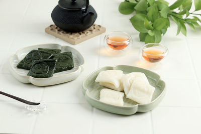 White and green korean pounded rice cake or jeolpyeon. servde with tea