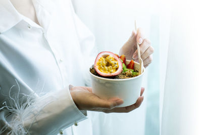 Midsection of woman holding ice cream in bowl