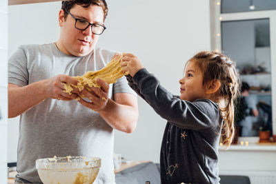 Side view of young woman holding food at home