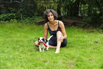 Portrait of teenage girl with dog on grass