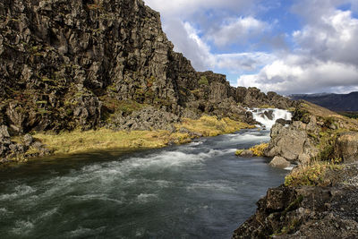 Scenic view of waterfall against sky