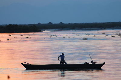 Man on boat in river against sky