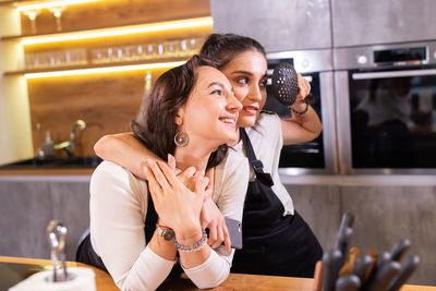 Young woman using mobile phone while sitting at cafe