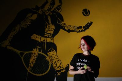 Full length of young woman standing against wall