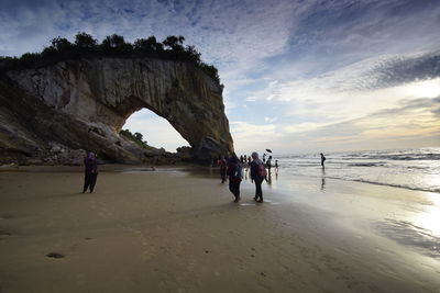 People at beach against sky