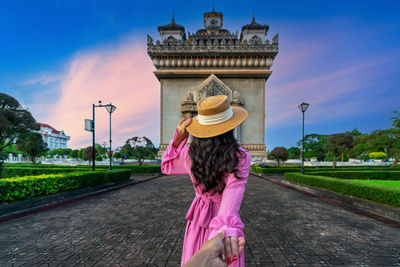 Rear view of woman standing against building