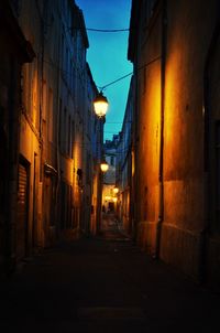 Narrow alley along buildings at night
