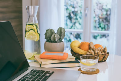 Morning time at home healthy breakfast laptop and drink son table. natural meal fruits and computer 