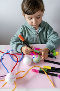 Full length of boy holding toy on table