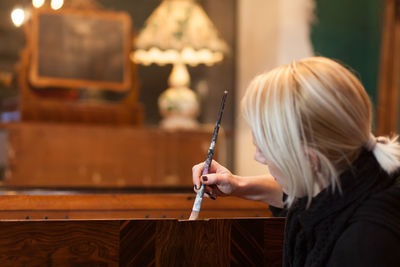 Woman painting furniture in store