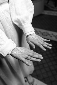 Close up of white henna arts on the bride's hand. bride's hands in shape of love heart - image