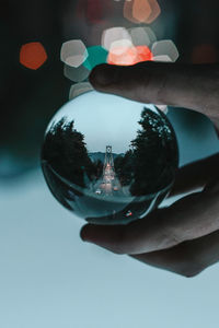 Close-up of hand holding glass with reflection