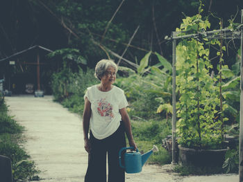 Rear view of woman standing against plants