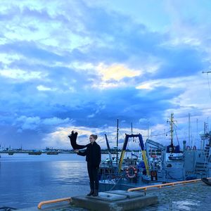 Man standing in boat against sky