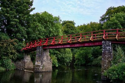 Bridge over river in forest against sky