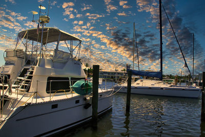 Sailboats moored in sea against sky