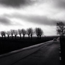 Empty road against cloudy sky