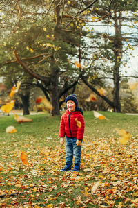 Full length portrait of man standing by autumn leaves