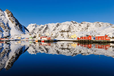 Remote fishing village reflected in water, lofoten, nordland, norway, europe