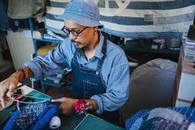 Man working over fabric on table