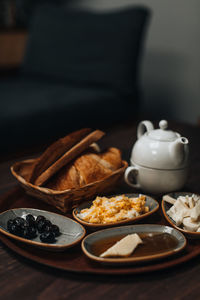 Traditional turkish breakfast with fried egg,  olives, croissant, bread, cheese, butter, honey, tea