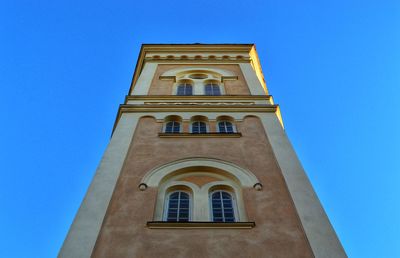 Low angle view of bell tower against blue sky