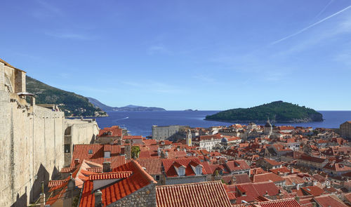 Townscape by sea against blue sky