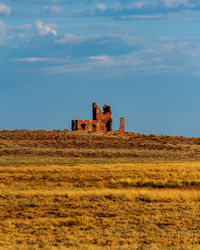 Old ruin on field against sky