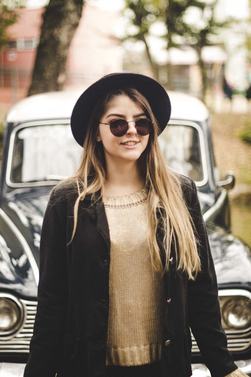 PORTRAIT OF YOUNG WOMAN IN SUNGLASSES