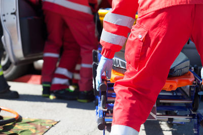 Rear view of paramedic holding stretcher on street