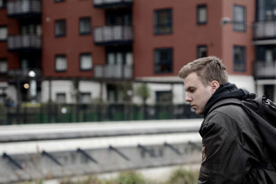 Side view of young man looking away in city