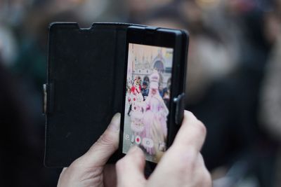 Midsection of woman photographing with mobile phone