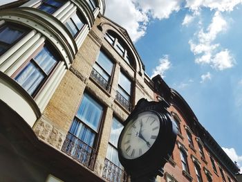 Low angle view of clock against buildings in city