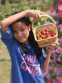 Smiling girl carrying strawberry basket