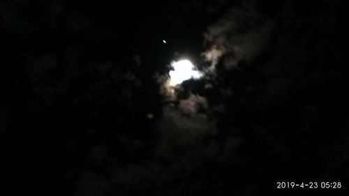 Low angle view of silhouette moon against sky at night