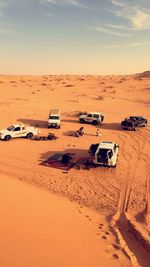 High angle view of off-road vehicles and people on desert land