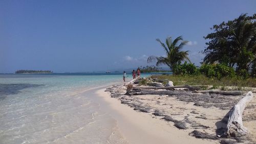 Scenic view of beach against clear blue sky