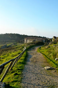 Road by river against clear sky