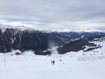 People on snowcapped mountain against sky