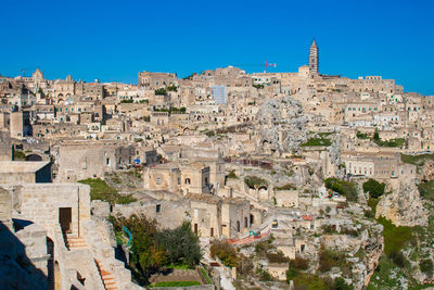 Buildings in town against clear blue sky