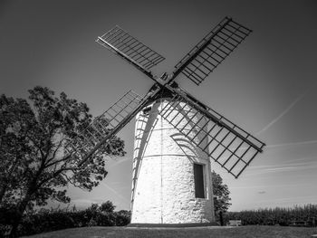 Traditional windmill on field against clear sky