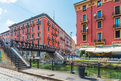 Bridge over canal amidst buildings in city against sky