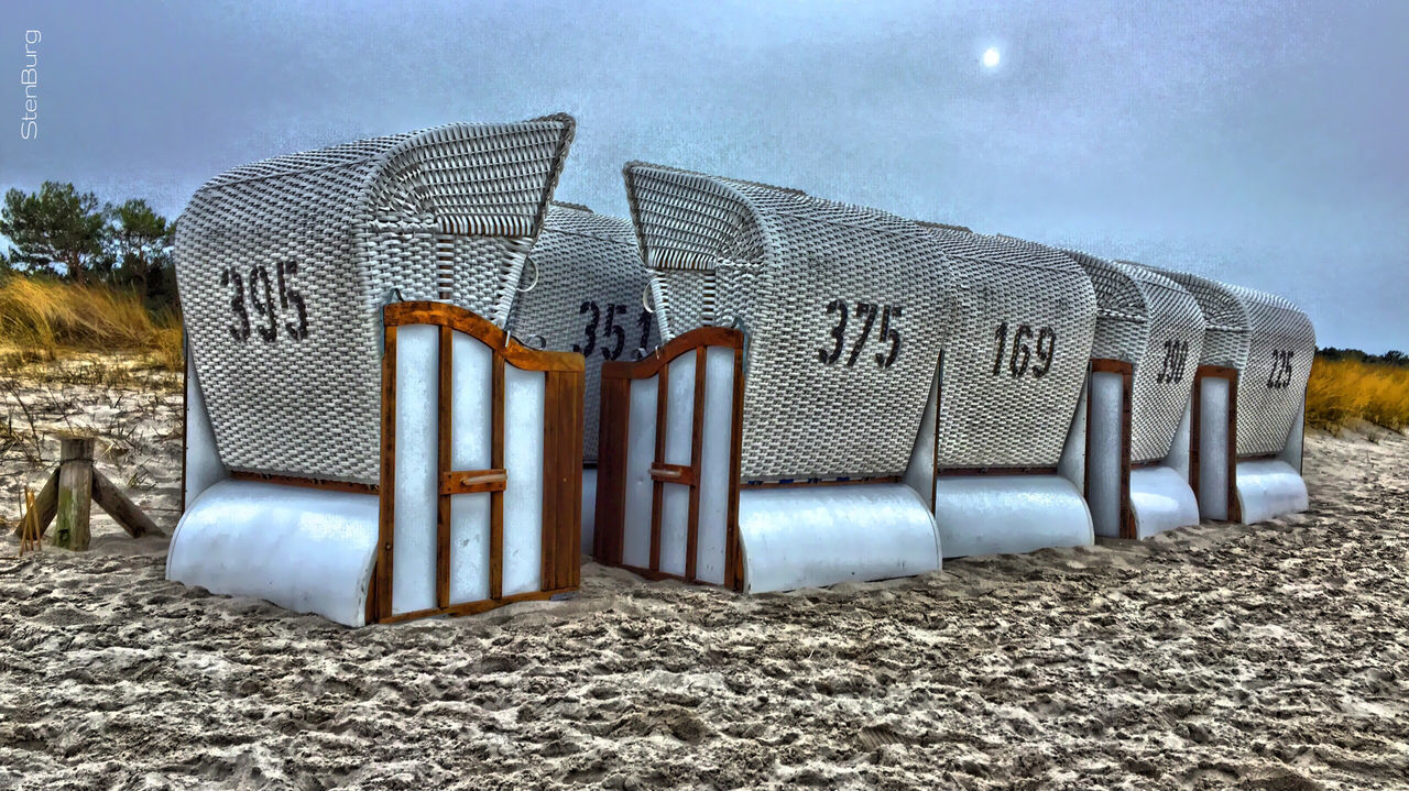 sky, beach, sand, absence, sunlight, built structure, blue, day, outdoors, shore, building exterior, no people, cloud - sky, architecture, tranquility, abandoned, empty, nature, cloud, shadow