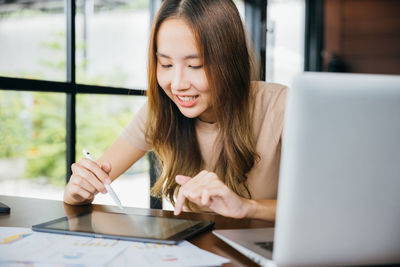 Businesswoman using laptop at table