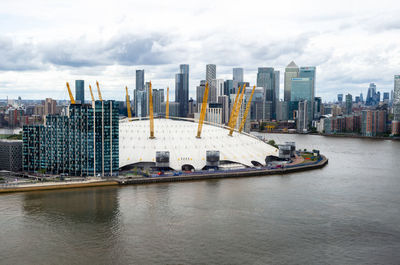 Scenic view of bay and buildings against sky